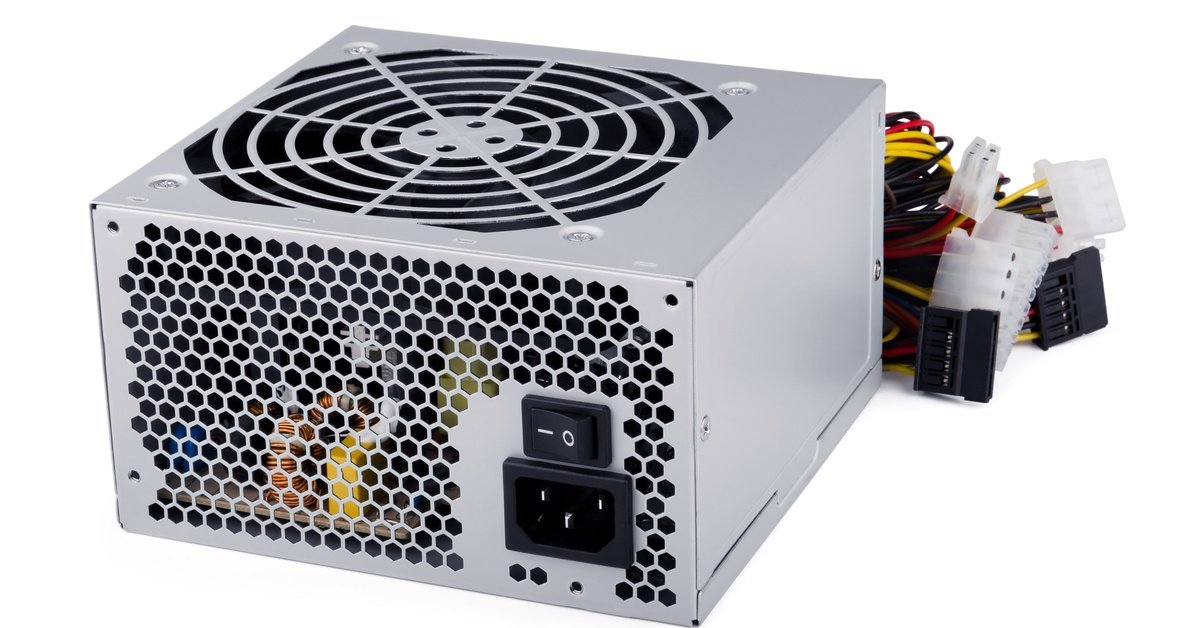 A computer power supply, in the shape of a cube, is against a white background. Wires stick out of the backside of the box.