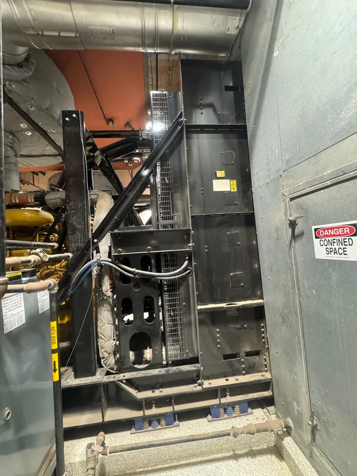 Radiator, hoses and support frame beside the Caterpillar 3516C diesel generator